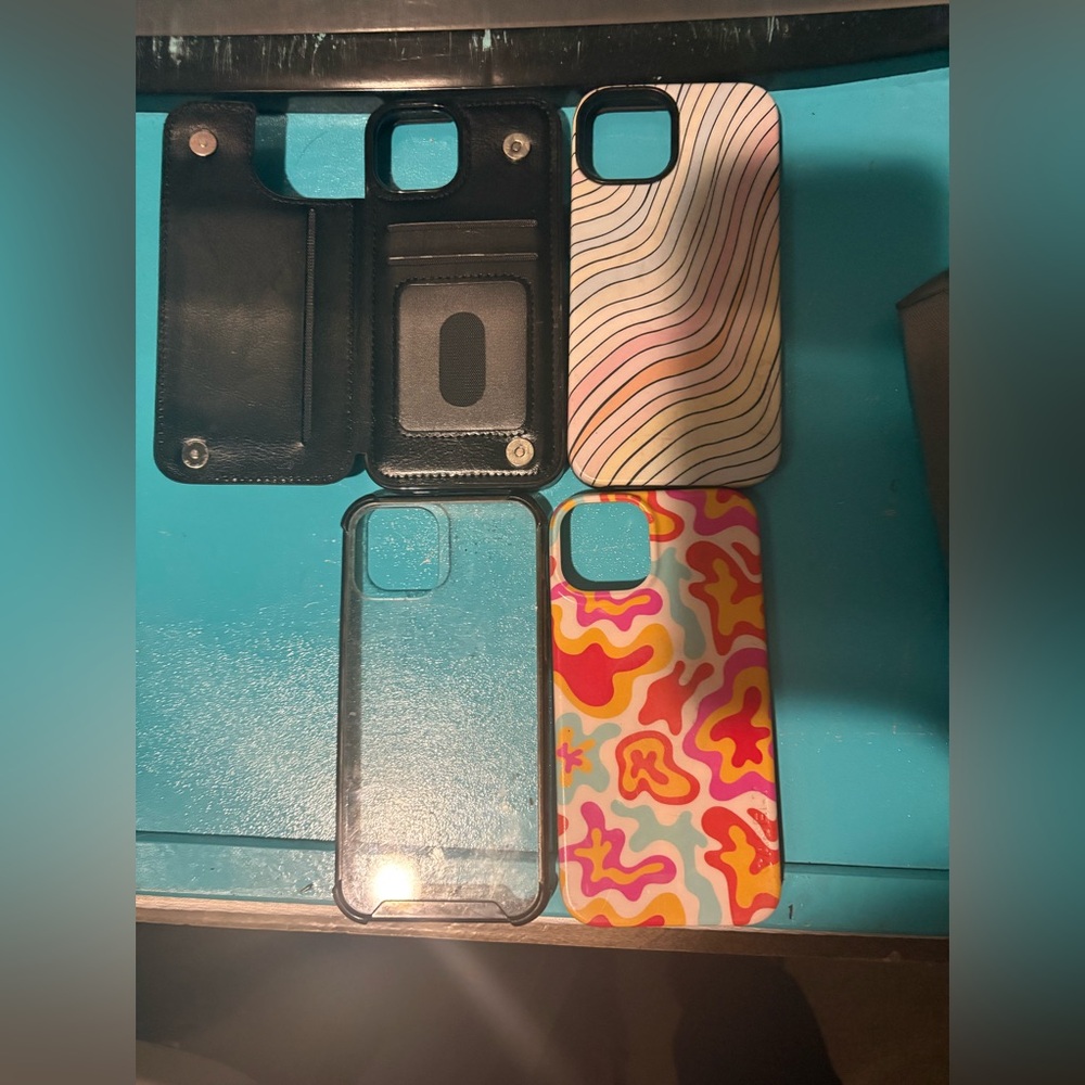 Four iPhone 15 phone cases, one clear one with a wallet and two CASLEY CASES